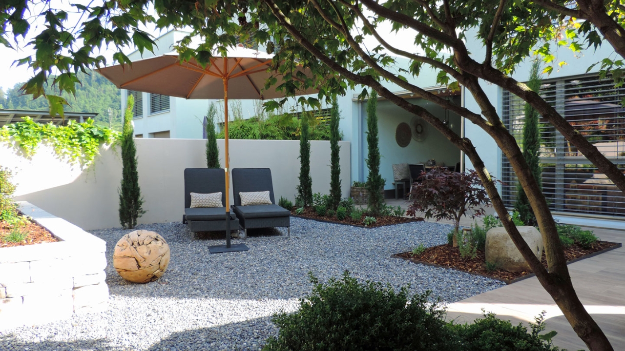 Säulenzypressen, duftende Kräuter mittendrin ein lauschiges Liegeplätzchen - mediterranes Flair zum Verweilen