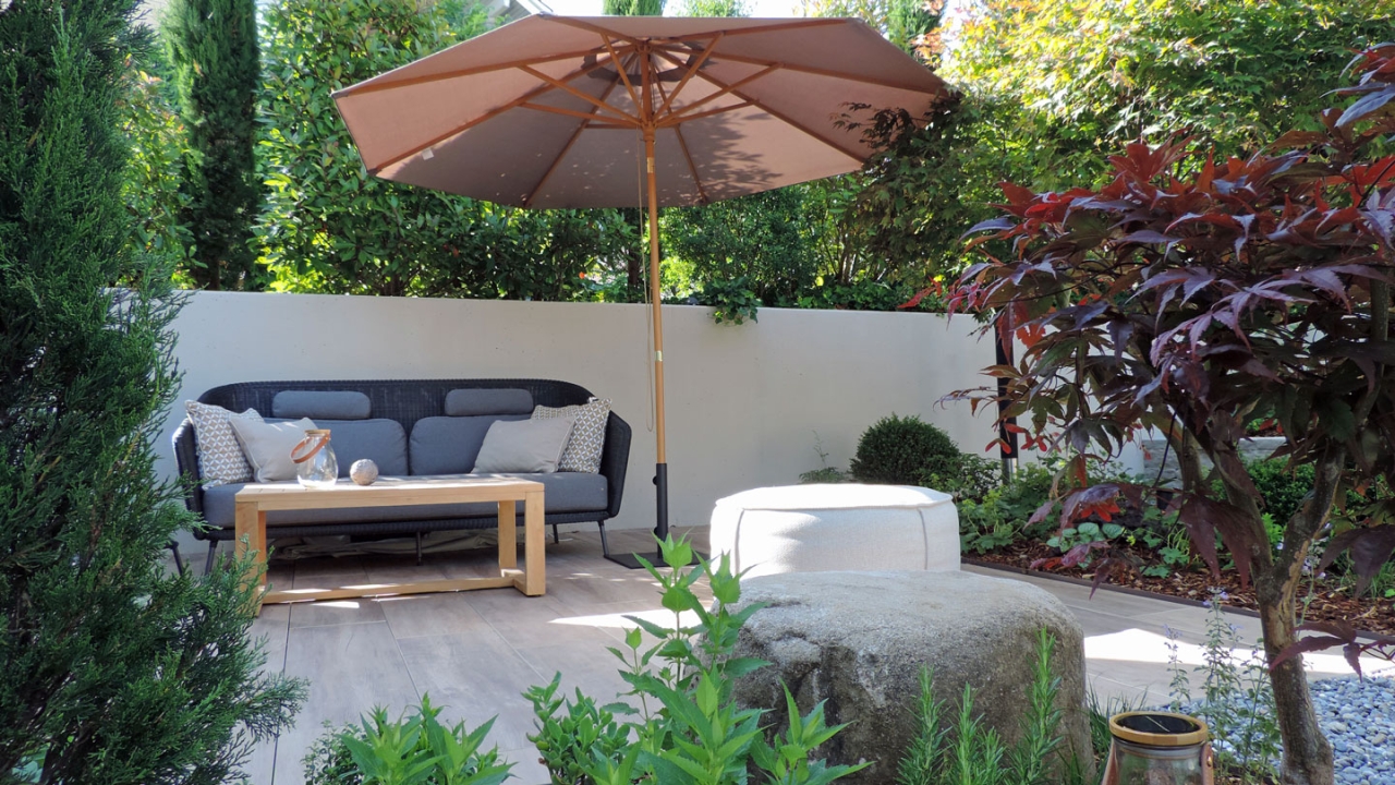 Boutique-Garten mit Loungplatz zum Verweilen. Klare Linien und verspielte Bepflanzung - einladend und harmonisch gestaltet